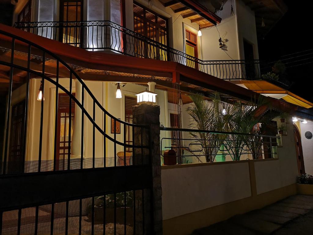 a building with a staircase and a balcony at night at White House Ella in Ella