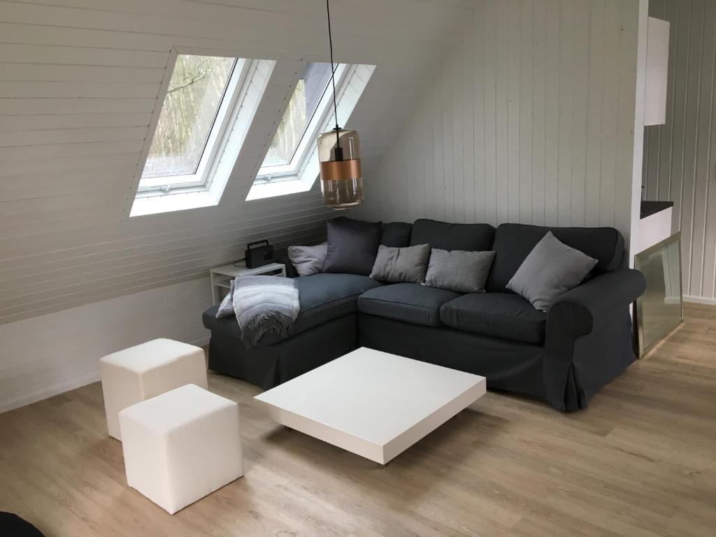 uma sala de estar com um sofá preto e uma mesa branca em Steffens Hof em Worpswede