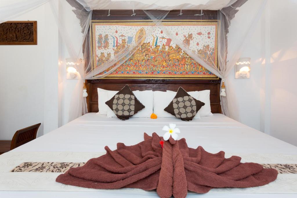 sypialnia z łóżkiem z kocem w obiekcie Bali Moon Guest House w mieście Ubud