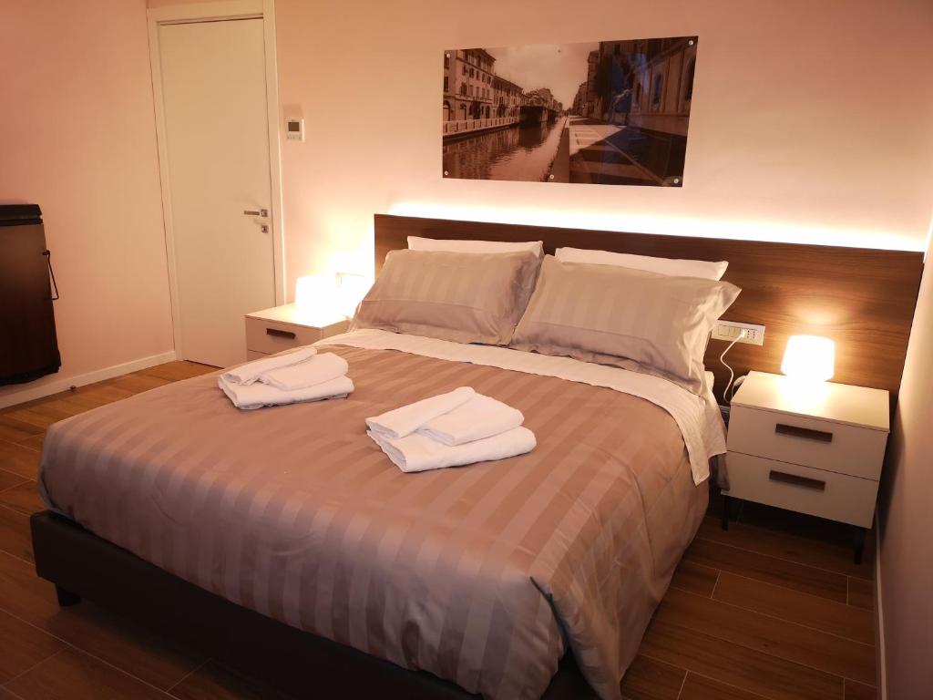 a bedroom with a large bed with two towels on it at 2 Navigli in Milan