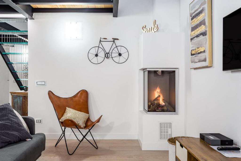 a living room with a fireplace and a chair at Ponte Milvio Luxury House in Rome