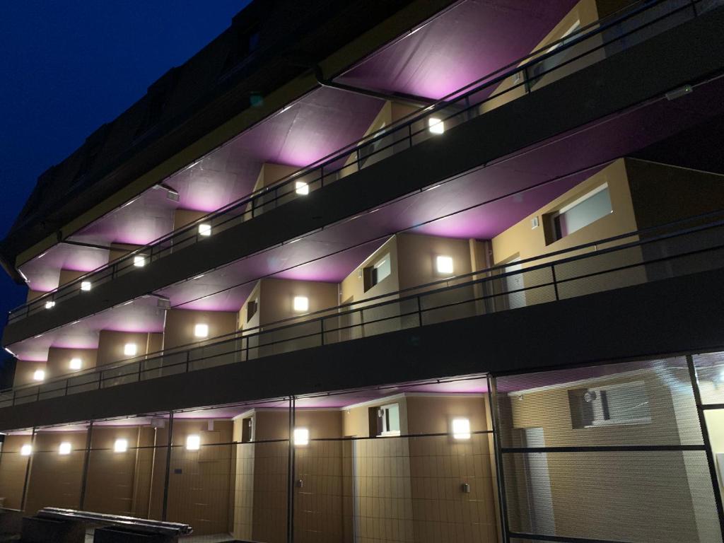 a building with purple lights on the side of it at Eh!Toi Self Motel in Etoy