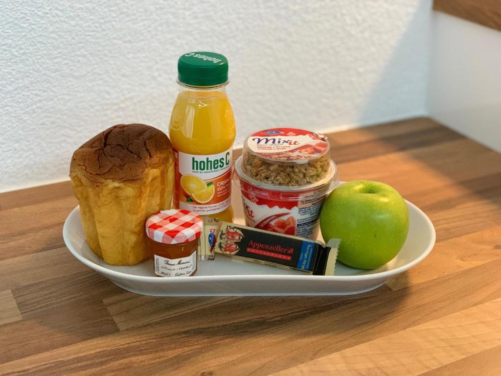 a plate with food and an apple on a table at Eh!Toi Self Motel in Etoy