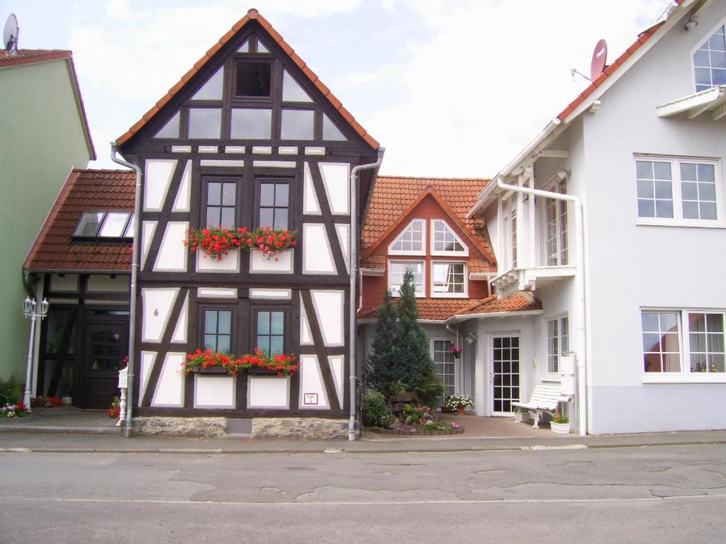 a black and white building with flowers in the window at Fachwerkhaus in D 63667 Nidda für 8 bis 12 Personen in Nidda
