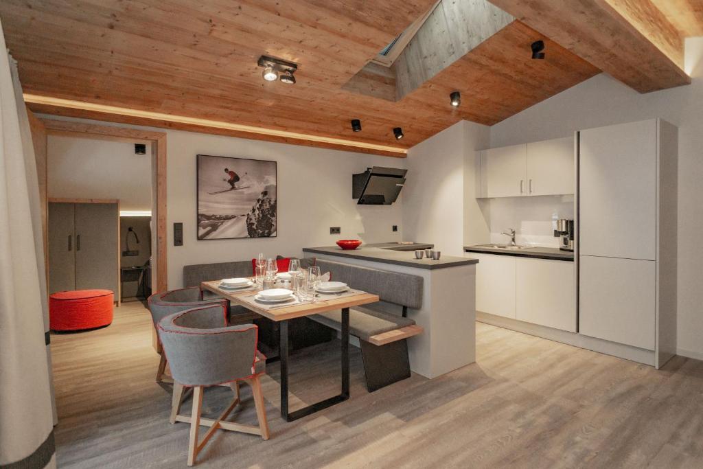 eine Küche und ein Esszimmer mit einem Tisch und Stühlen in der Unterkunft Appartements Erwin & Eleonore Hüttl - Penthouse in Neukirchen am Großvenediger