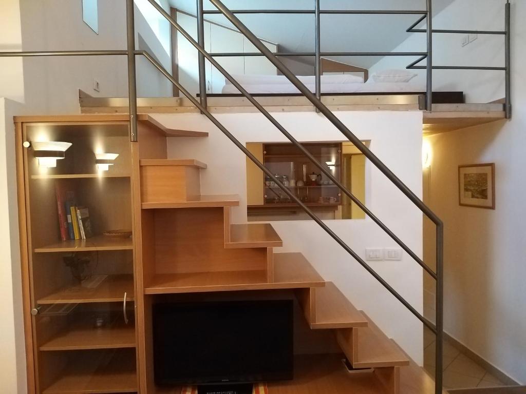 uma escada com grades de vidro e uma televisão num quarto em Soliman em Bressanone