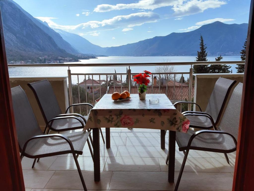 einen Tisch mit einer Blumenvase auf dem Balkon in der Unterkunft Apartments Nadja in Kotor