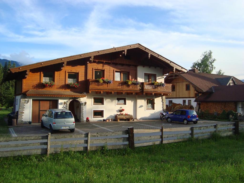 dom z dwoma samochodami zaparkowanymi przed nim w obiekcie Haus Harmonika w mieście Ramsau am Dachstein