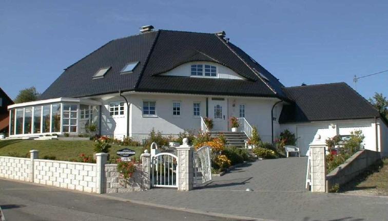 una grande casa bianca con tetto nero di Ferienwohnung Blau a Schweigen-Rechtenbach
