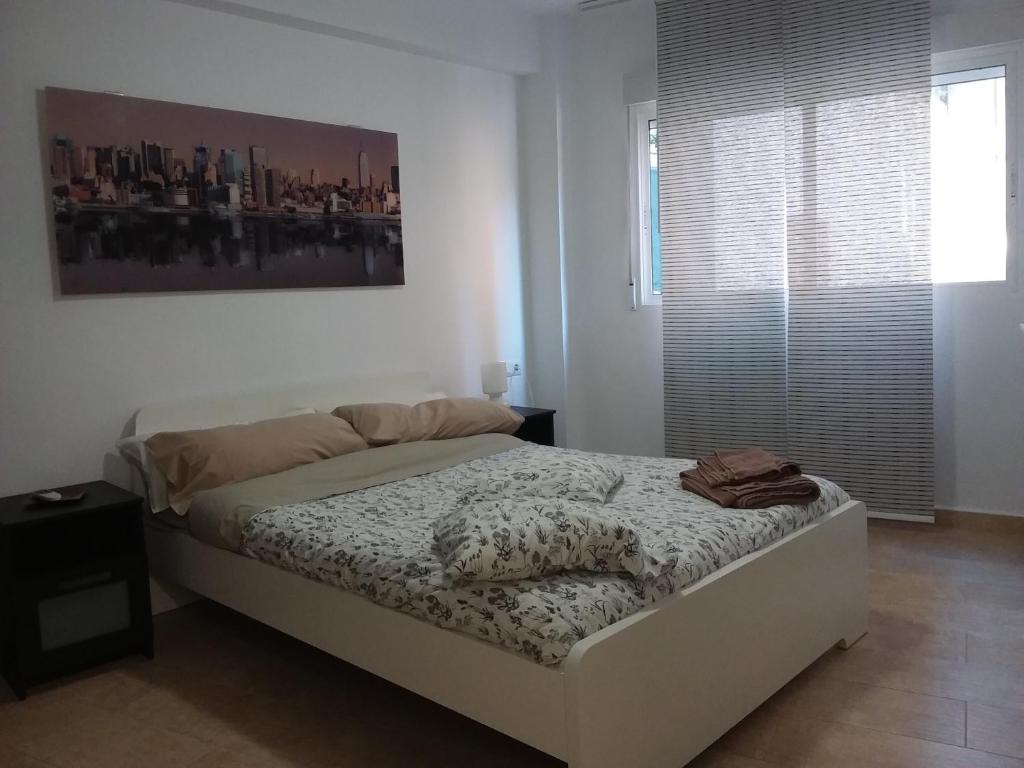 ein Schlafzimmer mit einem Bett und einem großen Fenster in der Unterkunft Apartamentos Naranja y Limòn in Valencia