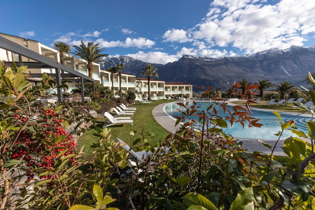 a resort with a pool and mountains in the background at Park Hotel Imperial in Limone sul Garda