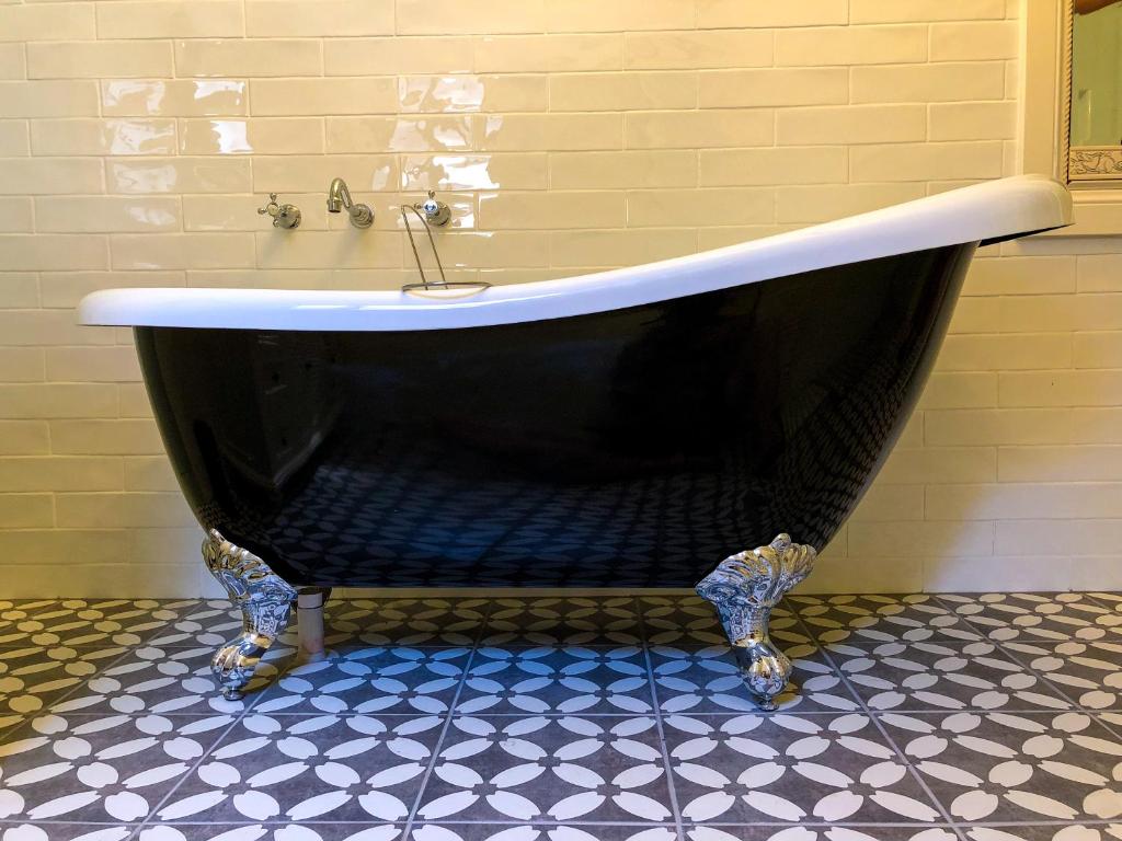 a black and white bath tub in a bathroom at Inglenook Cottage in Moonta