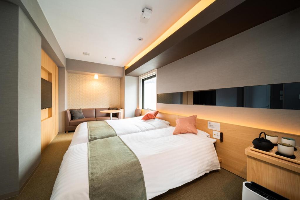 En eller flere senge i et værelse på Super Hotel Premier Ginza