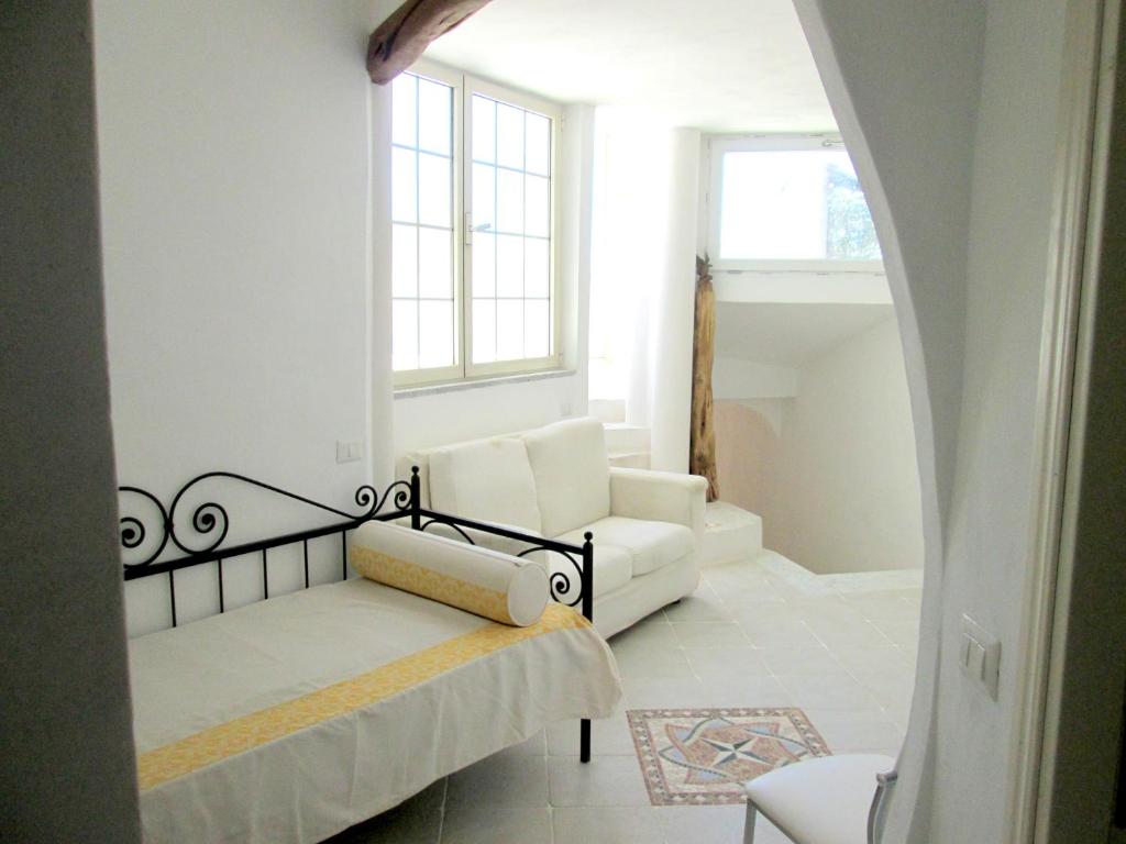 a living room with a white couch and a window at Sardinia Yellow House in Solanas