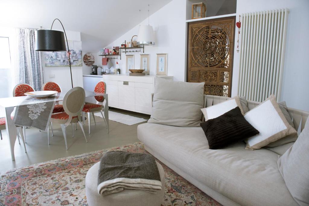 een woonkamer met een bank en een eetkamer bij "Nido del Falco" Palazzo Ricotti in Camerano