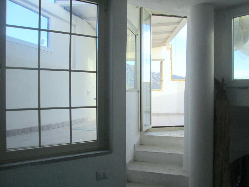an empty hallway with a window and stairs at Sardinia Yellow House in Solanas