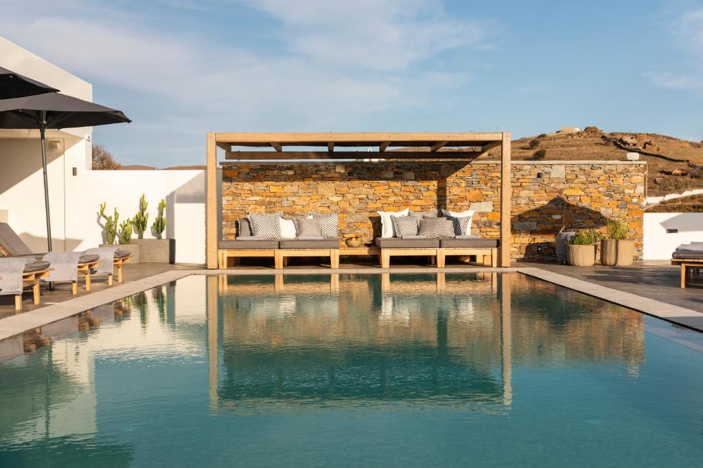 una casa con piscina frente a un edificio en Chora Kythnos Suites adults only en Kithnos