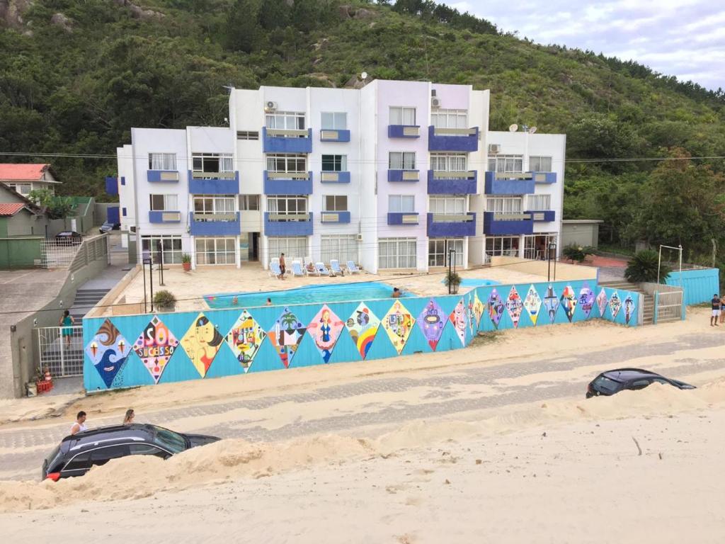 a building on the beach with a swimming pool at Via Praia Apart Hotel in Florianópolis