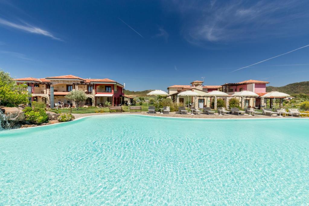 ein großer Pool vor einem Resort in der Unterkunft Hotel Sa Cheya Relais & Spa in Alghero