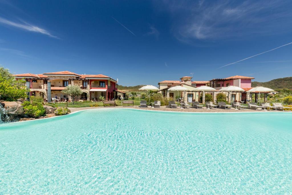 アルゲーロにあるHotel Sa Cheya Relais & Spaのリゾートの正面に大きなスイミングプールがあります。