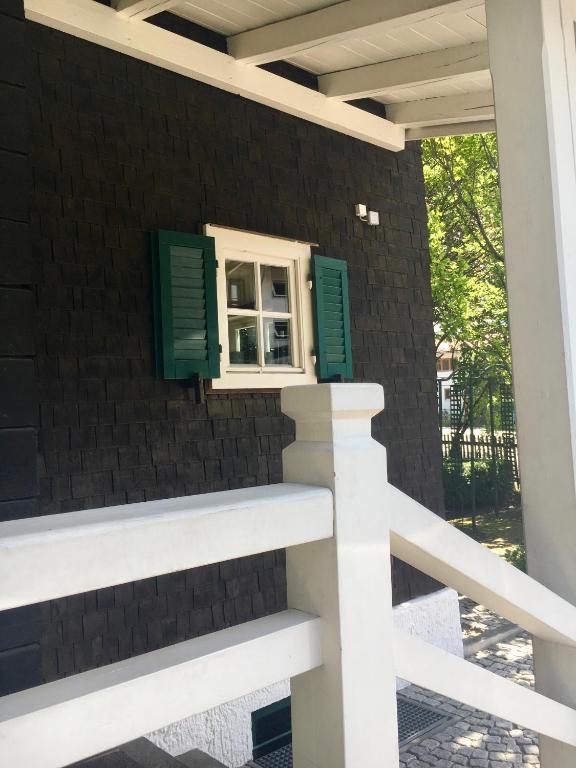 a window on a brick wall with green shutters at Alpchalet Oberstdorf in Oberstdorf
