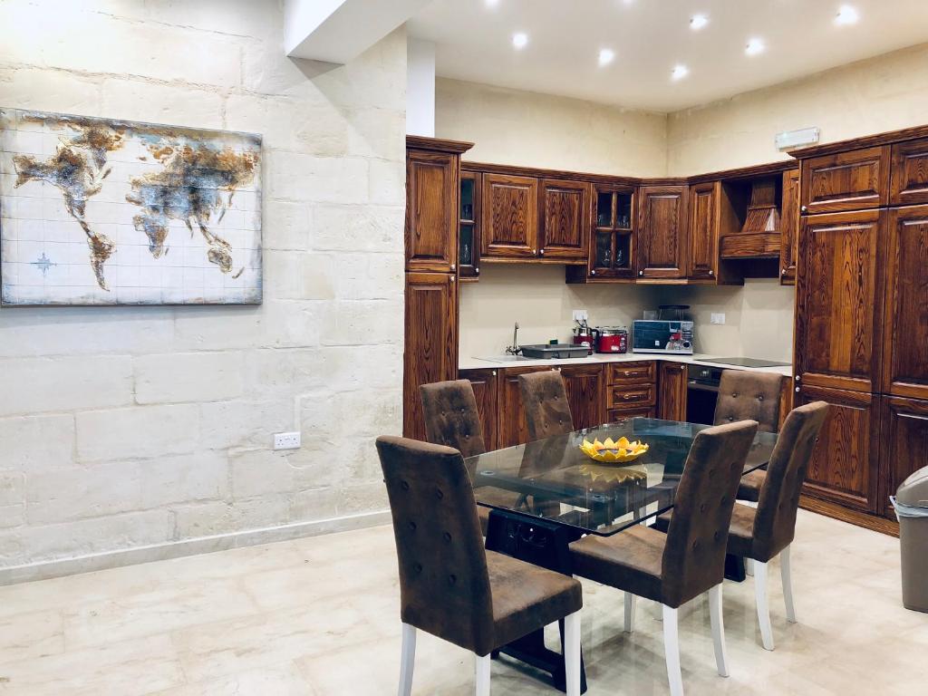 a kitchen with a table and chairs and a map on the wall at Modern Maltese House in Sliema