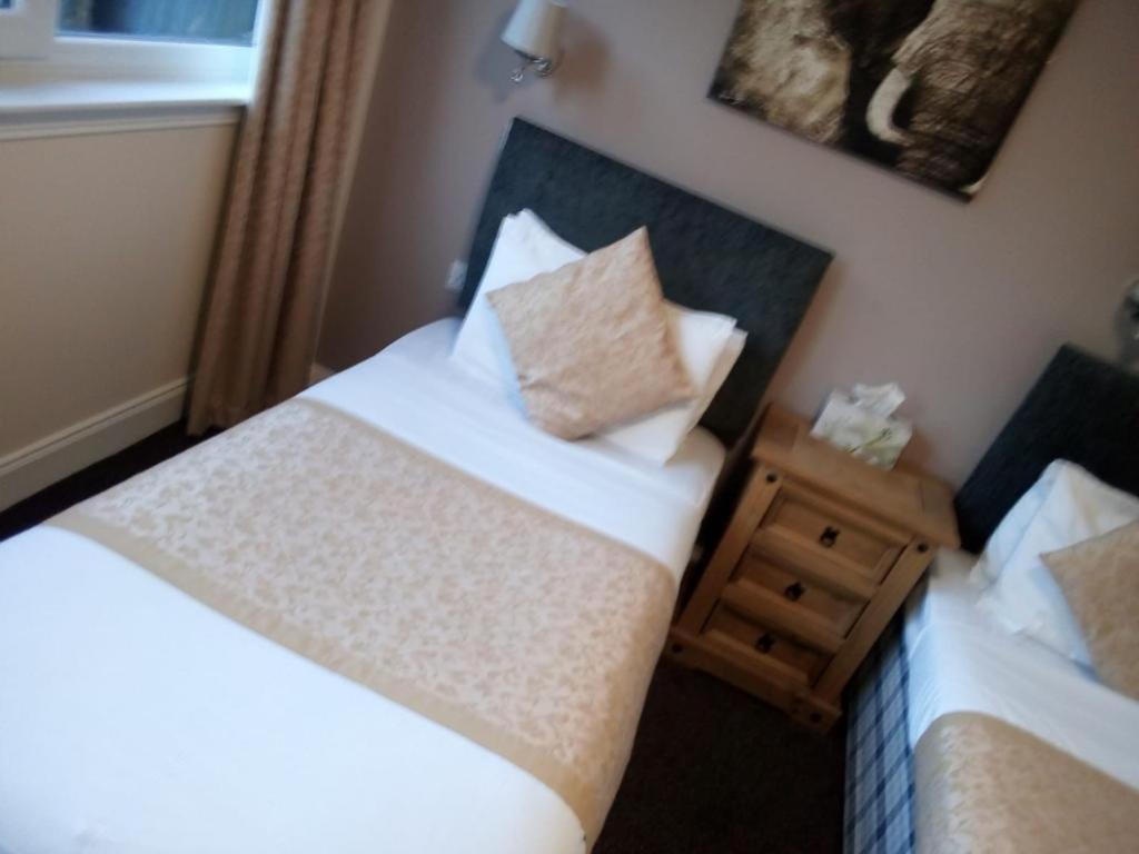 a bedroom with two beds and two pillows at The Waverley Inn in Dingwall