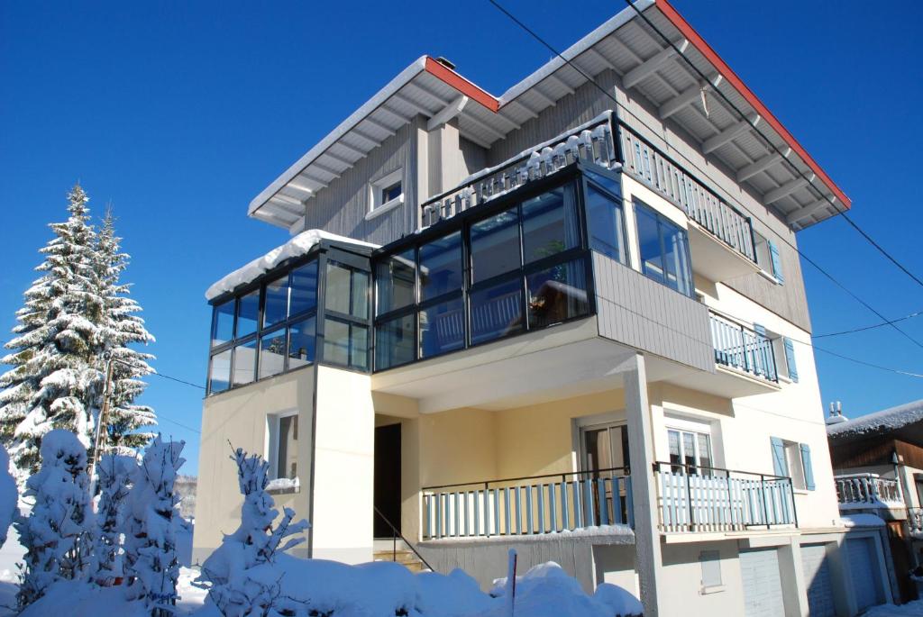 une maison avec un balcon dans la neige dans l'établissement Neige & Soleil Les Rousses, aux Rousses