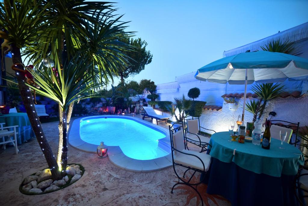 een zwembad met een tafel en een palmboom bij B&B Oasi Degli Angeli in San Giovanni Teatino