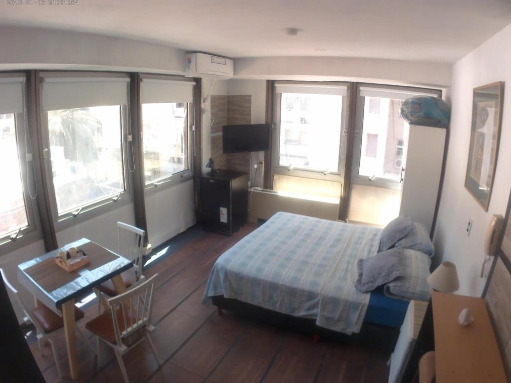 1 dormitorio con cama, mesa y ventanas en Apartment Esmeralda 740 Microcentro Downtown Area en Buenos Aires