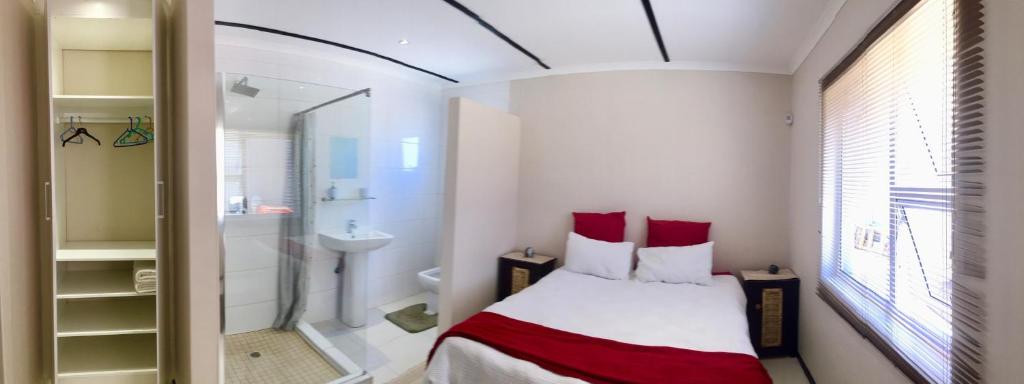 a small bathroom with a bed and a shower at Man Cave Suite in Swakopmund