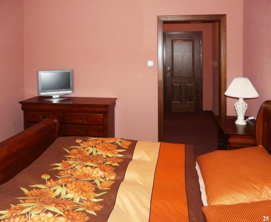 sypialnia z łóżkiem i telewizorem na komodzie w obiekcie Resort Maják w mieście Horní Soběšovice