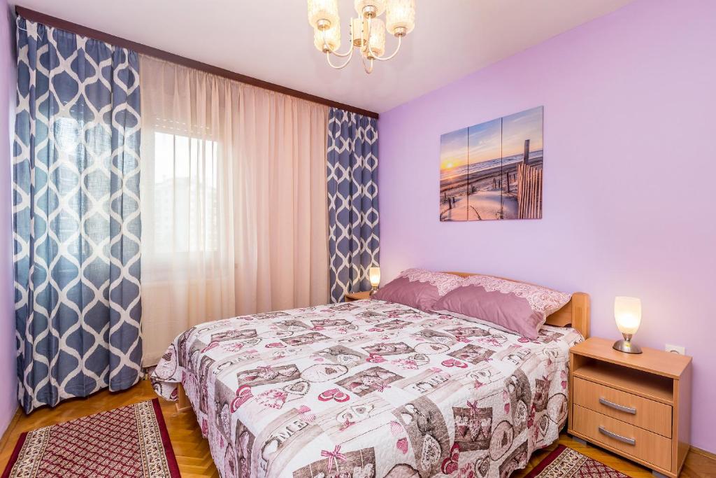 sypialnia z łóżkiem i żyrandolem w obiekcie Apartment Infinity w mieście Rijeka