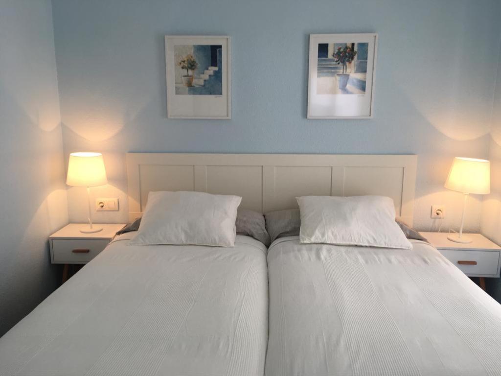 2 camas en un dormitorio con 2 lámparas en ambos lados en Apartamento Cantabrico, en Cádiz