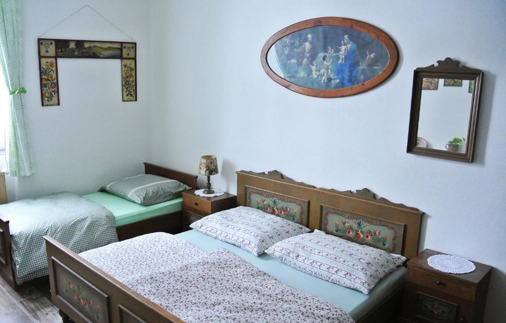 1 dormitorio con 2 camas y espejo en la pared en Restaurace a penzion Ubrousku prostři se, en Nová Bystřice