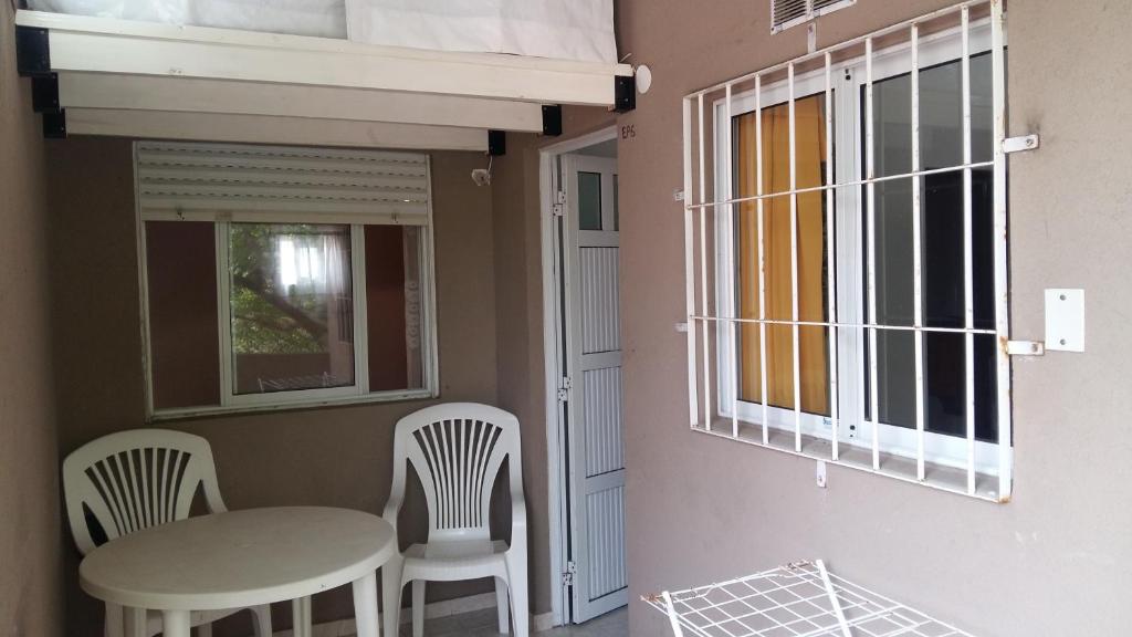 a room with a table and chairs and a window at Departamento en Centro de Mar de Ajo 1º piso in Mar de Ajó