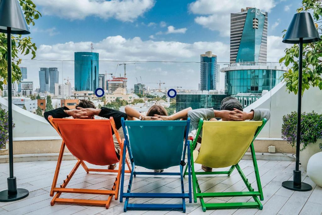 فندق 65، روتشيلد تل أبيب - فندق أن أطلس البوتيكي في تل أبيب: مجموعة من الناس ينامون على كراسي على السطح