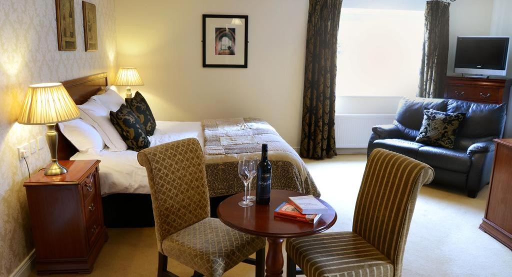a hotel room with a bed and a table and chairs at Donegal Manor in Donegal