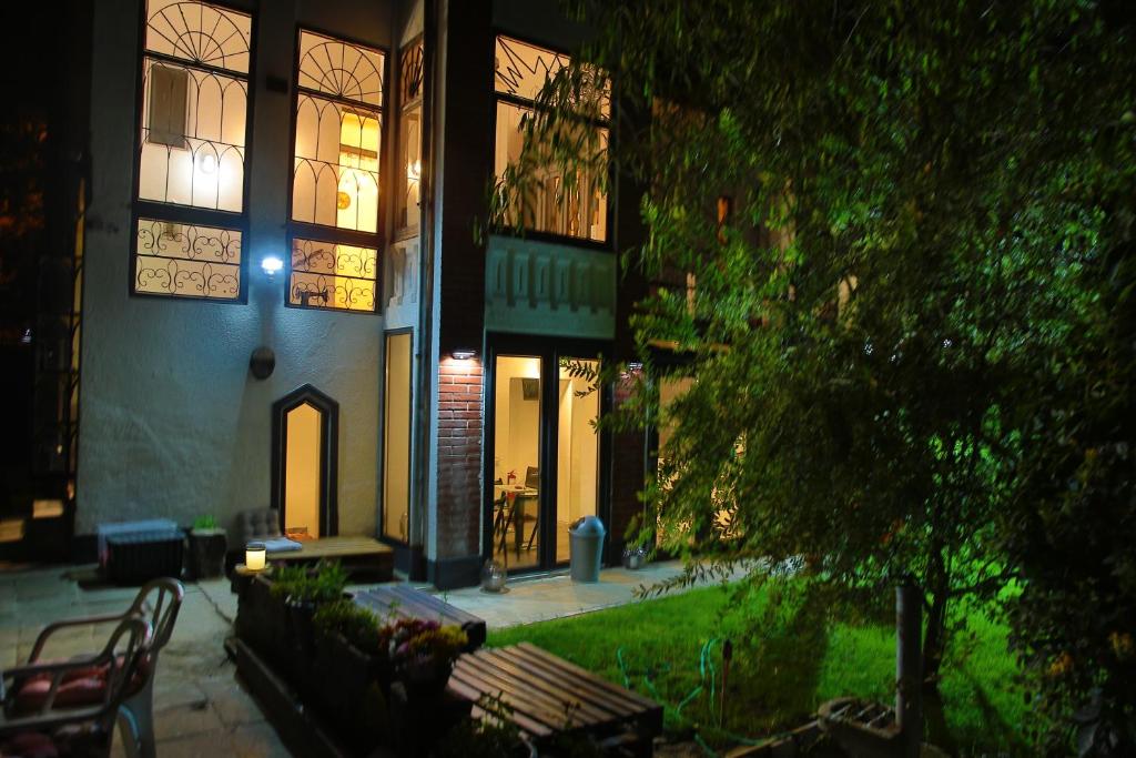 a building at night with benches in front of it at Passpartout Hostel in Timişoara