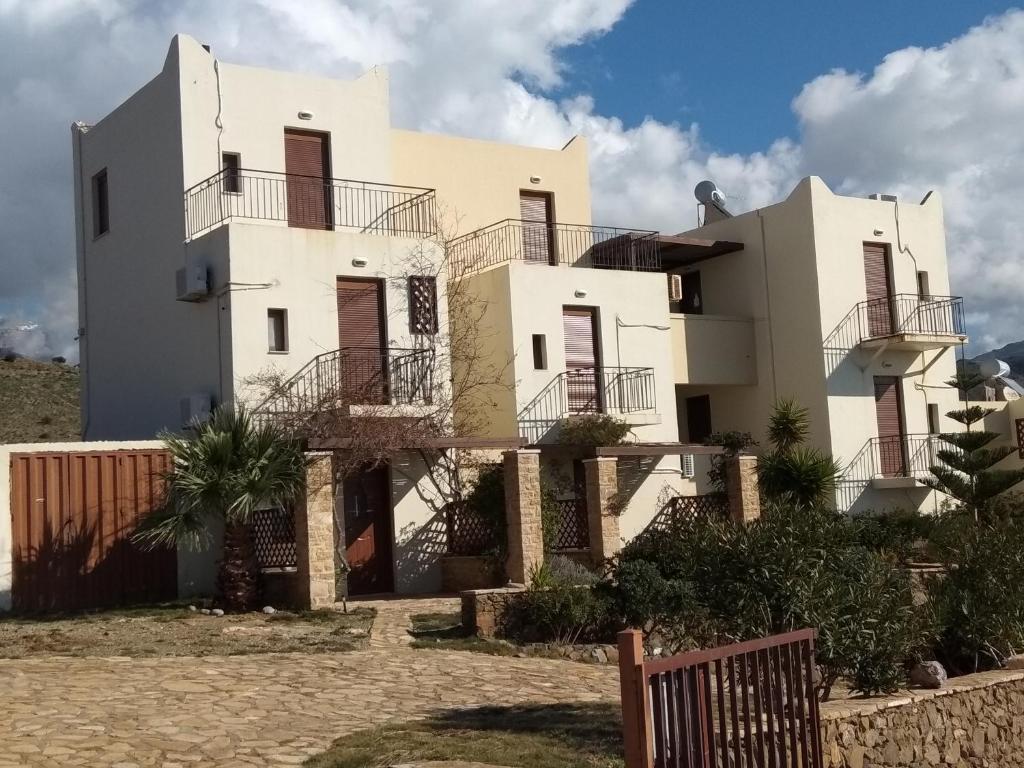 Una casa blanca con balcones en un lateral. en Kavos Melissa Studios, en Agios Pavlos