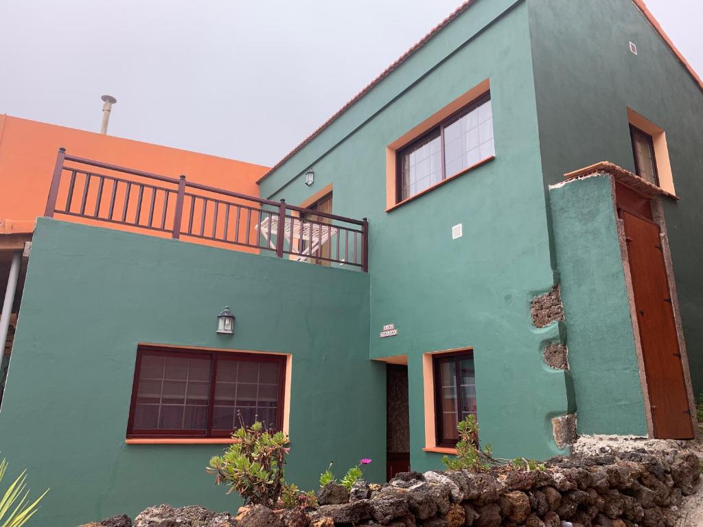 a blue and green house with a balcony at Casa Tanajara in El Pinar del Hierro