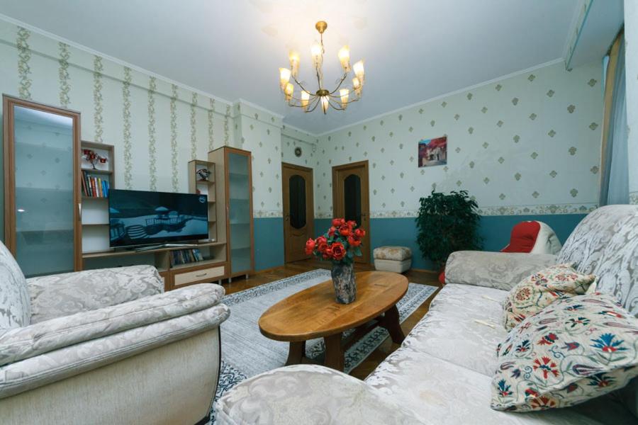 una sala de estar con 2 sofás y una mesa con flores en Three-room apartments at the Polytechnic Institute, en Kiev