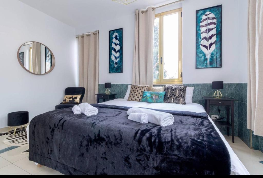 een slaapkamer met een groot bed en handdoeken bij King David Luxury Apartments in Jeruzalem