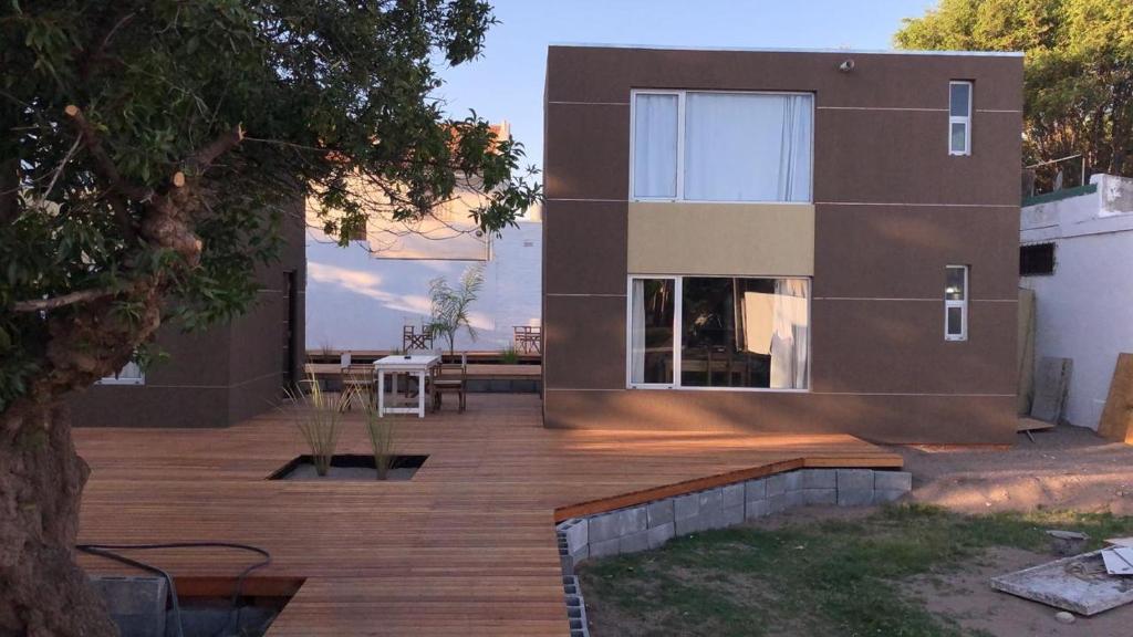 a house with a wooden deck next to a building at Duplex Rio Uruguay 161 in Monte Hermoso