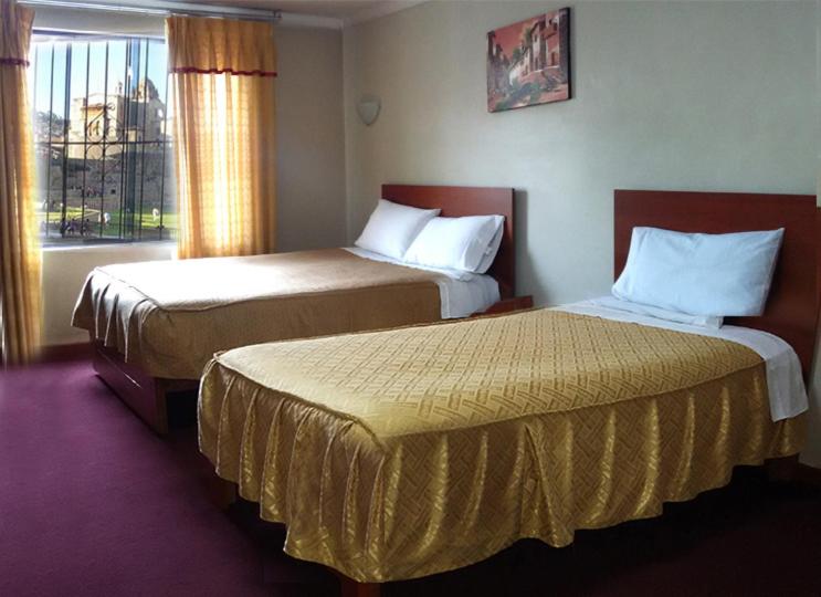 ein Hotelzimmer mit 2 Betten und einem Fenster in der Unterkunft Hostal Lucerito in Cusco