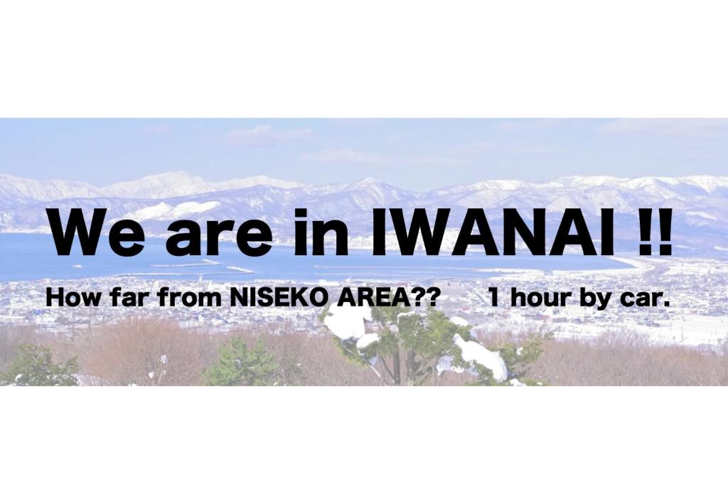 Ein Schild, auf dem steht, wir sind in Naniani mit Bergen im Hintergrund. in der Unterkunft Iwanai Kogen Hotel in Iwanai