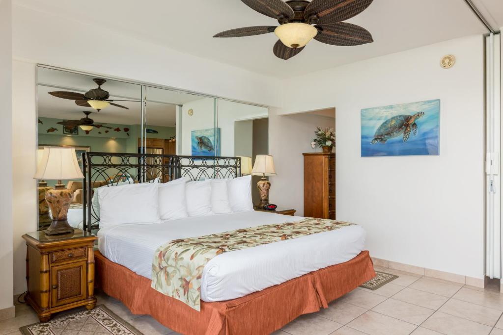 a bedroom with a bed and a ceiling fan at Castle Waikīkī Shore in Honolulu