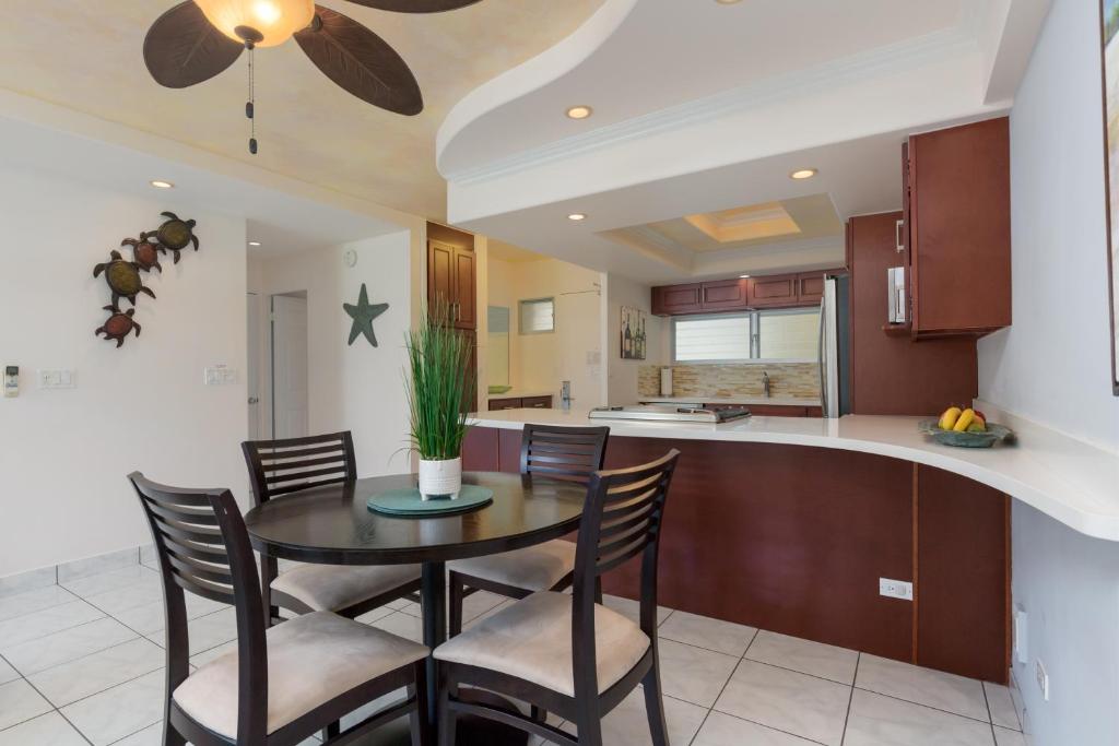 a kitchen and dining room with a table and chairs at Castle Waikīkī Shore in Honolulu