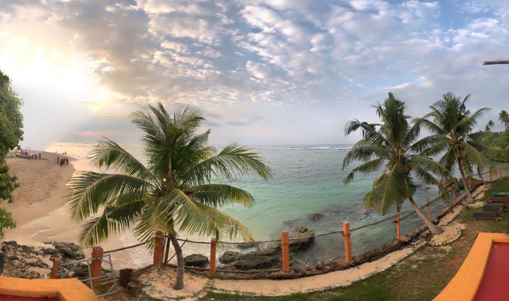 マータラにあるSayuri Beach Hotelのヤシの木と海の景色を望む