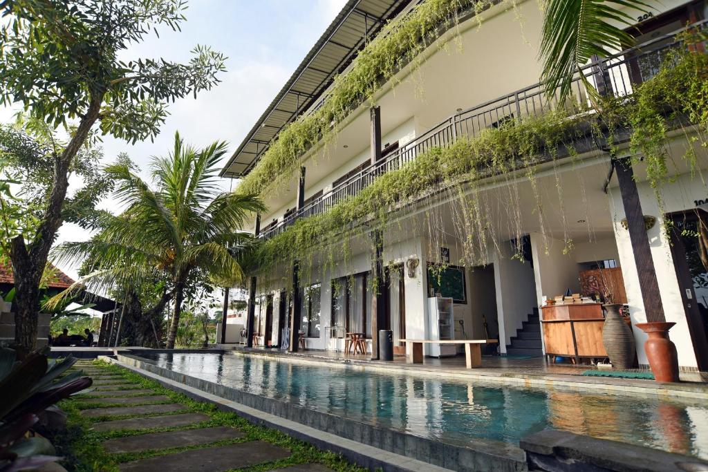 a courtyard of a building with a swimming pool at Grandpa Guest House in Canggu